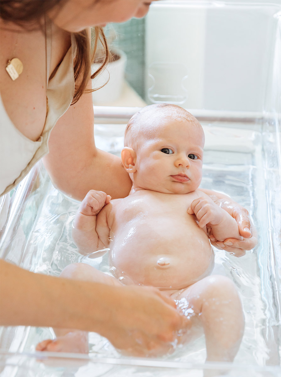 Mother bathes baby in her hired hospital bassinet